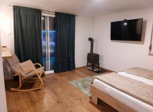 ein Schlafzimmer mit Bett, Stuhl und Fernseher in der Unterkunft Rivergreen in Banja Luka