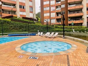 una piscina con sedie a sdraio e un edificio di Moderno Apartamento Sabaneta- Century Tower II a Envigado