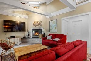 ein Wohnzimmer mit einem roten Sofa und einem Kamin in der Unterkunft Lake Home with Private Beach and Hot Tub in Ossipee + 28 Fotos