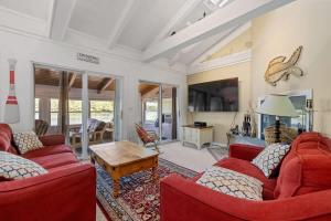 ein Wohnzimmer mit zwei roten Sofas und einem Tisch in der Unterkunft Lake Home with Private Beach and Hot Tub in Ossipee