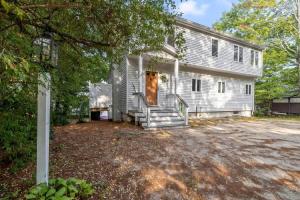 ein altes weißes Haus mit einem großen Hof in der Unterkunft Lake Home with Private Beach and Hot Tub in Ossipee