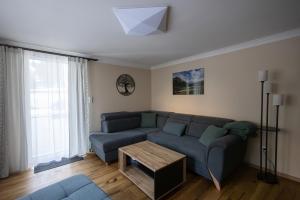 a living room with a blue couch and a table at Heimathaus Hettegger neue gemütliche Ferienwohnung in Grossarl +16 photos