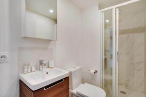 a bathroom with a toilet and a sink and a shower at La lumière de Paris in Levallois-Perret +26 photos