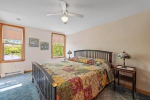 ein Schlafzimmer mit Bett und Deckenventilator in der Unterkunft Pond Retreat at the Beach in New Durham