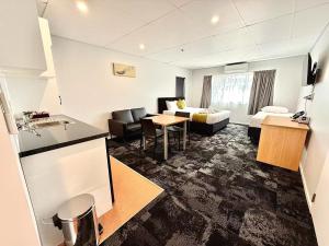 a hotel room with a kitchen and a living room at Anglesea Motel and Conference Centre in Hamilton