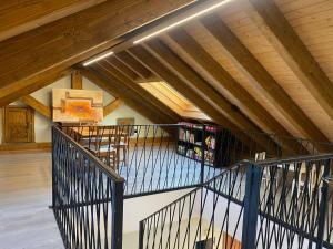 an attic room with wooden ceilings and a staircase at El Balcón De Muniellos in Oballo
