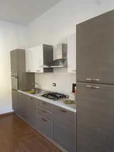 a kitchen with stainless steel appliances and white cabinets at L'Oasi di Pace di Elena in Ottone +36 photos
