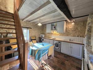 a kitchen with a table with a table cloth on it at Séjour Authentique au Pigeonnier avec Wifi et Parking - FR-1-616-101 in Monsac