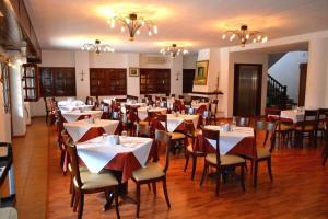 a dining room filled with tables and chairs with white tables at Hotel Aglaida Apartments in Tsagarada