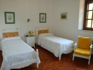 1 dormitorio con 2 camas y silla amarilla en Villa Iolanda, en Giarre