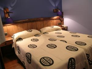 1 dormitorio con 2 camas en una habitación con luces moradas en Hostal Xaloa Orio en Orio