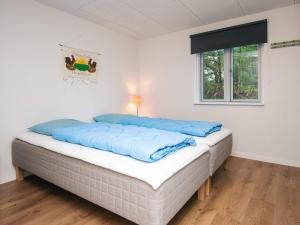 une chambre avec un lit avec des oreillers bleus dessus dans l'établissement 8 person holiday home in Blåvand-By Traum, à Blåvand
