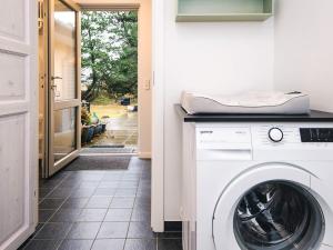 une buanderie avec une laveuse et une sécheuse à côté d'une porte dans l'établissement 8 person holiday home in Blåvand-By Traum, à Blåvand