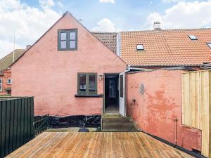 a large red house with a wooden deck at 4 person holiday home in Marstal-By Traum in Marstal