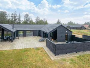 a black house with a patio in a field at Luxury Retreat in Romo - By Traum Ferienwohnungen in Kongsmark