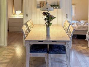 a dining room table with a vase of flowers on it at 6 person holiday home in Nibe in Nibe