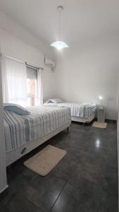 una camera da letto con due letti e una finestra di Amplio departamento 6p a Concepción del Uruguay Altre 19 foto