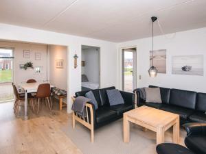 a living room with a black couch and a table at 4 star holiday home in Rømø-By Traum in Sønderby