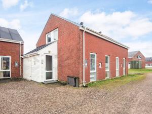 a red brick building with a white garage at 4 star holiday home in Rømø-By Traum in Sønderby