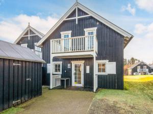 un granero negro grande con garaje en 8 person holiday home in Gjern, en Gjern