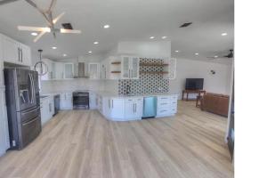 a large kitchen with white cabinets and stainless steel appliances at Bush Master Suite, Moovalya Keys canal in Parker
