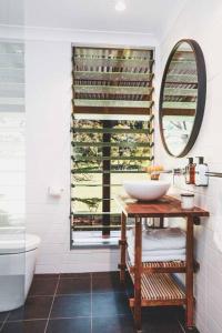 a bathroom with a sink and a mirror at Banksia at barranca KV - Luxury Villa in Kangaroo Valley