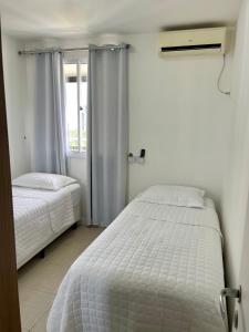 a bedroom with two beds and a window at Barra Family Resort com piscina e spa, 2 quartos in Rio de Janeiro +19 photos