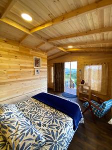 Un dormitorio con una cama en una cabaña de troncos en Serás Libre Refugio, en Zipaquirá