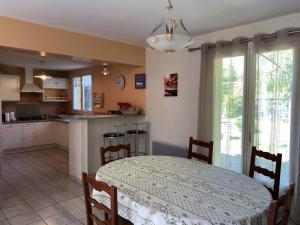 a kitchen and dining room with a table and a table and chairs at Maison tranquille avec jardin et wifi, 3 chambres - FR-1-336-116 in Avrillé