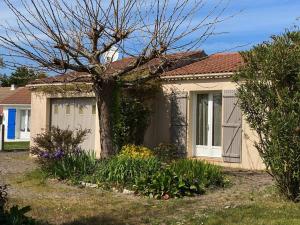 a house with a tree in front of it at Maison tranquille avec jardin et wifi, 3 chambres - FR-1-336-116 in Avrillé