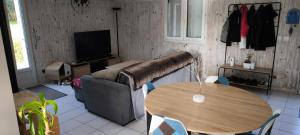 a living room with a table and a couch at Bienvenue en Gâtine in Le Retail