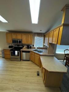 a large kitchen with wooden cabinets and a skylight at Cliff Hanger, River access with dock in Parker