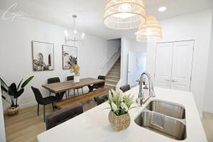 a kitchen and dining room with a sink and a table at BoHo Modern Retreat King Bed,Fireplace,Disney in Edmonton