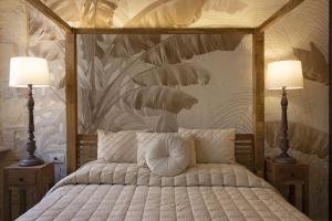 卡利亚里La Maison Coloniale Suite e Zona Wellness free的一间卧室,有一张大床,配有两盏灯