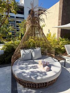 a hammock bed with pillows on a patio at Luxurious 2-Bedroom Condo in Nuevo Vallarta  +2 photos