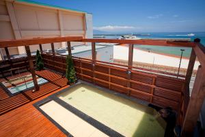 a balcony with a view of a beach and the ocean at Harbor Hotel Kaigetsu in Sumoto