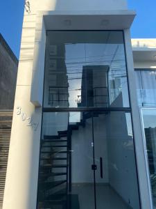 a glass facade of a building with a staircase at Apartamento em Uruguaiana in Uruguaiana