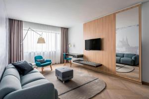 a living room with a blue couch and a television at Courtyard by Marriott Brno in Brno +93 photos