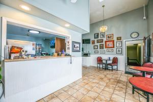 a restaurant with a counter and tables and chairs at Hotel 8 in Fergus Falls