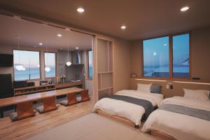 zwei Betten in einem Zimmer mit Fenstern in der Unterkunft seaside cottage KOBUSTAY in Rausu