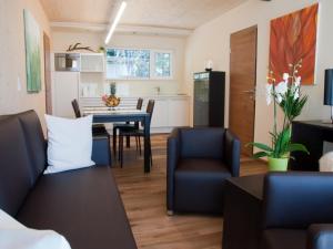 ein Wohnzimmer mit einem Tisch und Stühlen sowie eine Küche in der Unterkunft Alpresort Tirol in Reith bei Seefeld