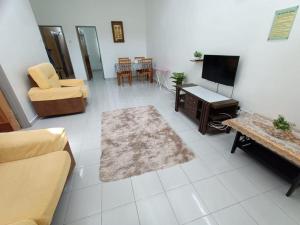 a living room with a couch and a tv at MJ Homestay Bintong in Kangar