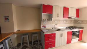 a kitchen with red and white cabinets and a counter at Edificio K&C in Sogamoso