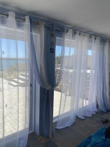 a room with white curtains and a large window at Driftwater in Velddrif +2 photos