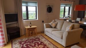 a living room with a couch and a television at 2br-sleeps4-pool-freeparking-trenythonestate in Par