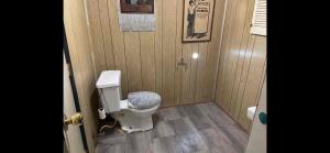 a bathroom with a toilet in a wooden wall at Tarawa drive in Cincinnati