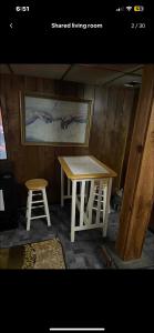 a table and stool in a room with a painting at Tarawa drive in Cincinnati