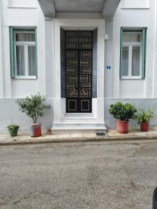 a front door of a white house with potted plants at Rental room pilika4 in Athens +11 photos