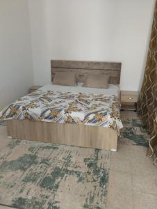 a bedroom with a bed with a blanket and a rug at Dar El Yasamine in Houmt Souk +3 photos