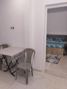 a table and chair in a room with a bedroom at Dar El Yasamine in Houmt Souk